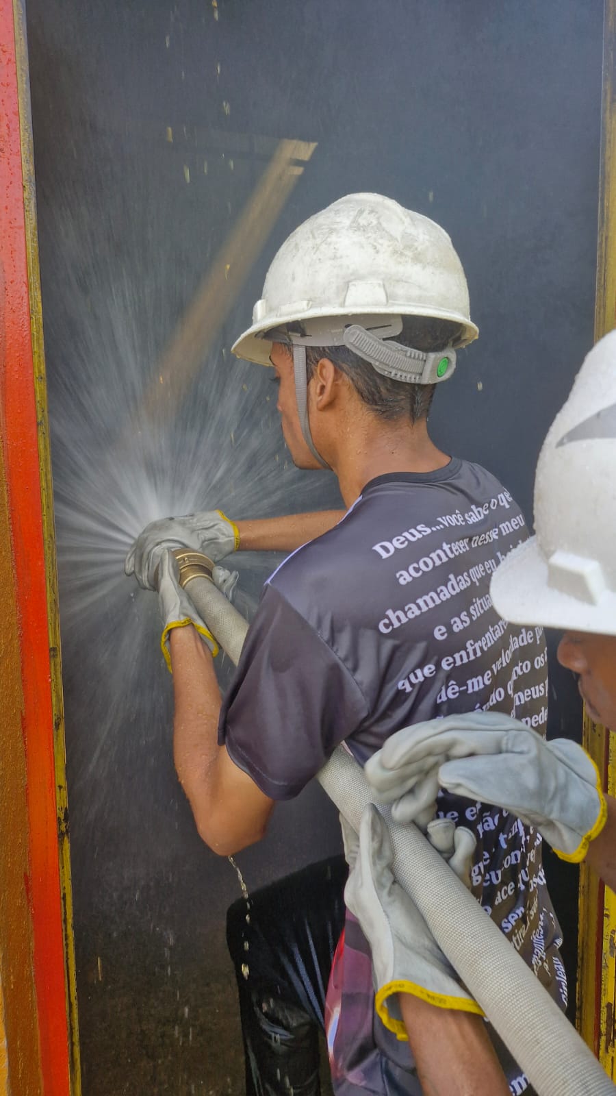 Treinamento prático de combate a incêndio em contêiner com mangueira